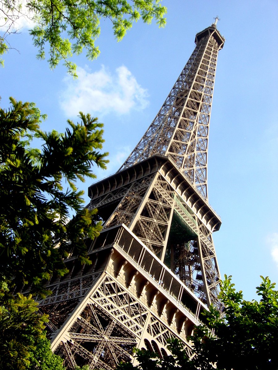 an eiffel tower is shown seen through the trees