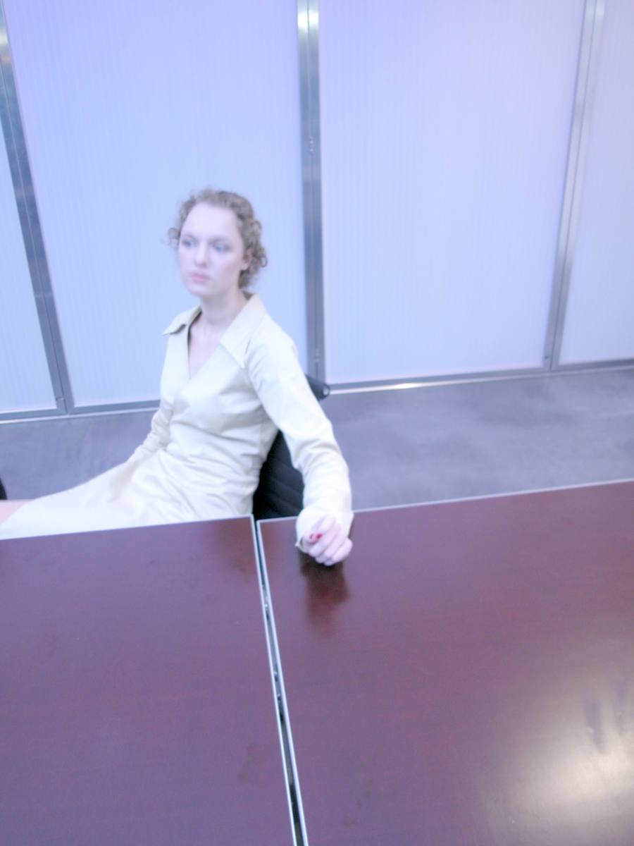 a lady is sitting in the corner of a table