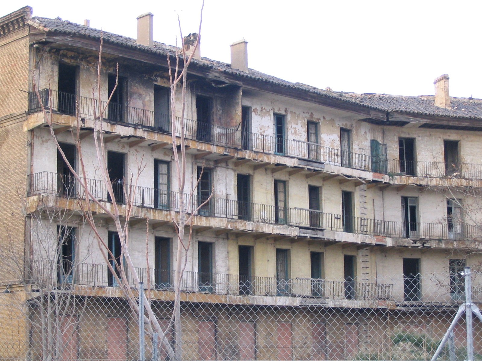 an old building with no doors behind a chain link fence