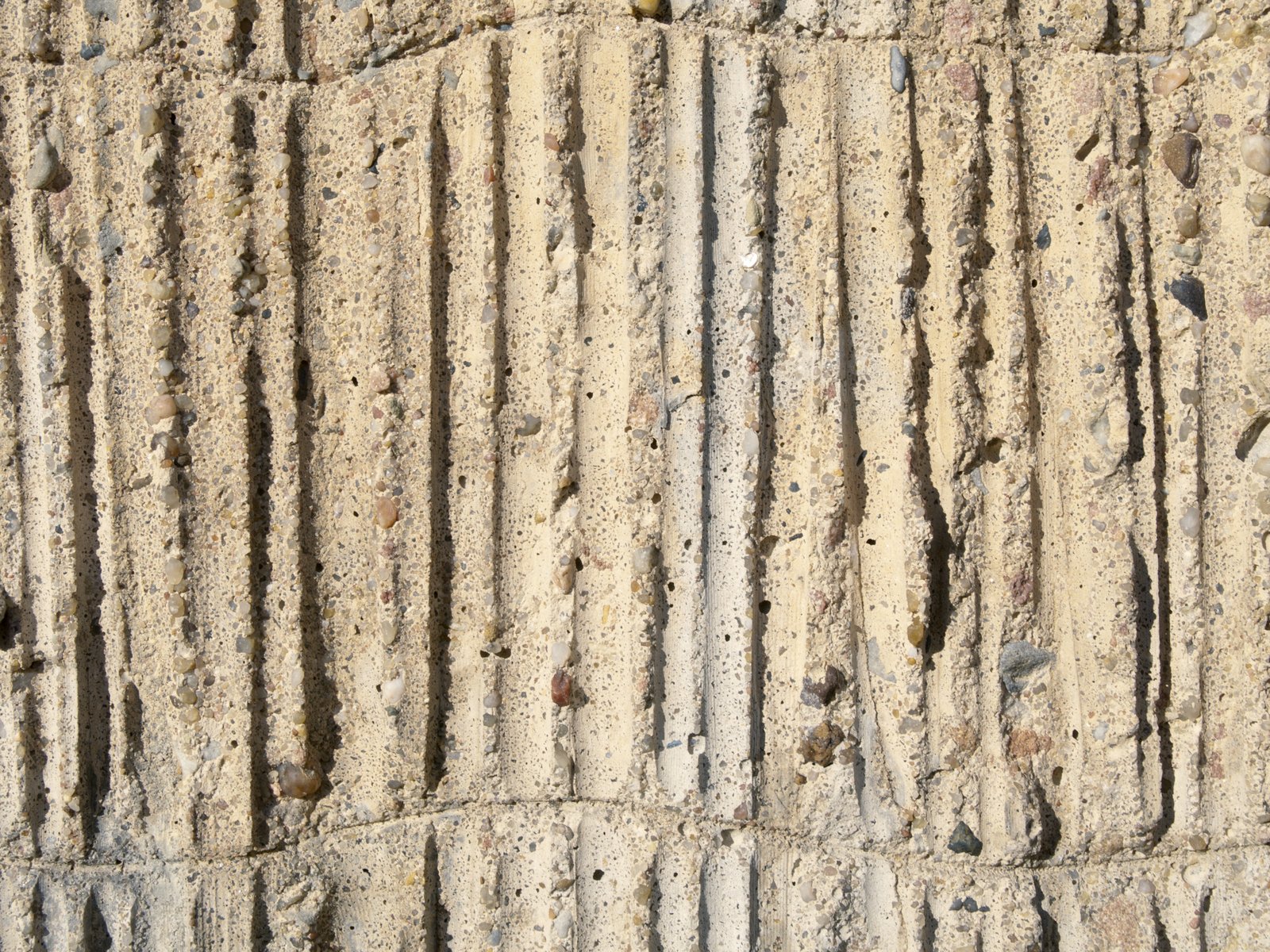 the wall made out of cement blocks that is in the sand