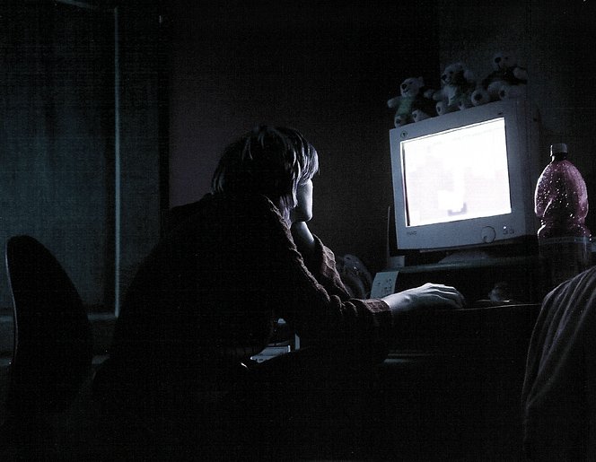 a woman sitting in front of a computer screen