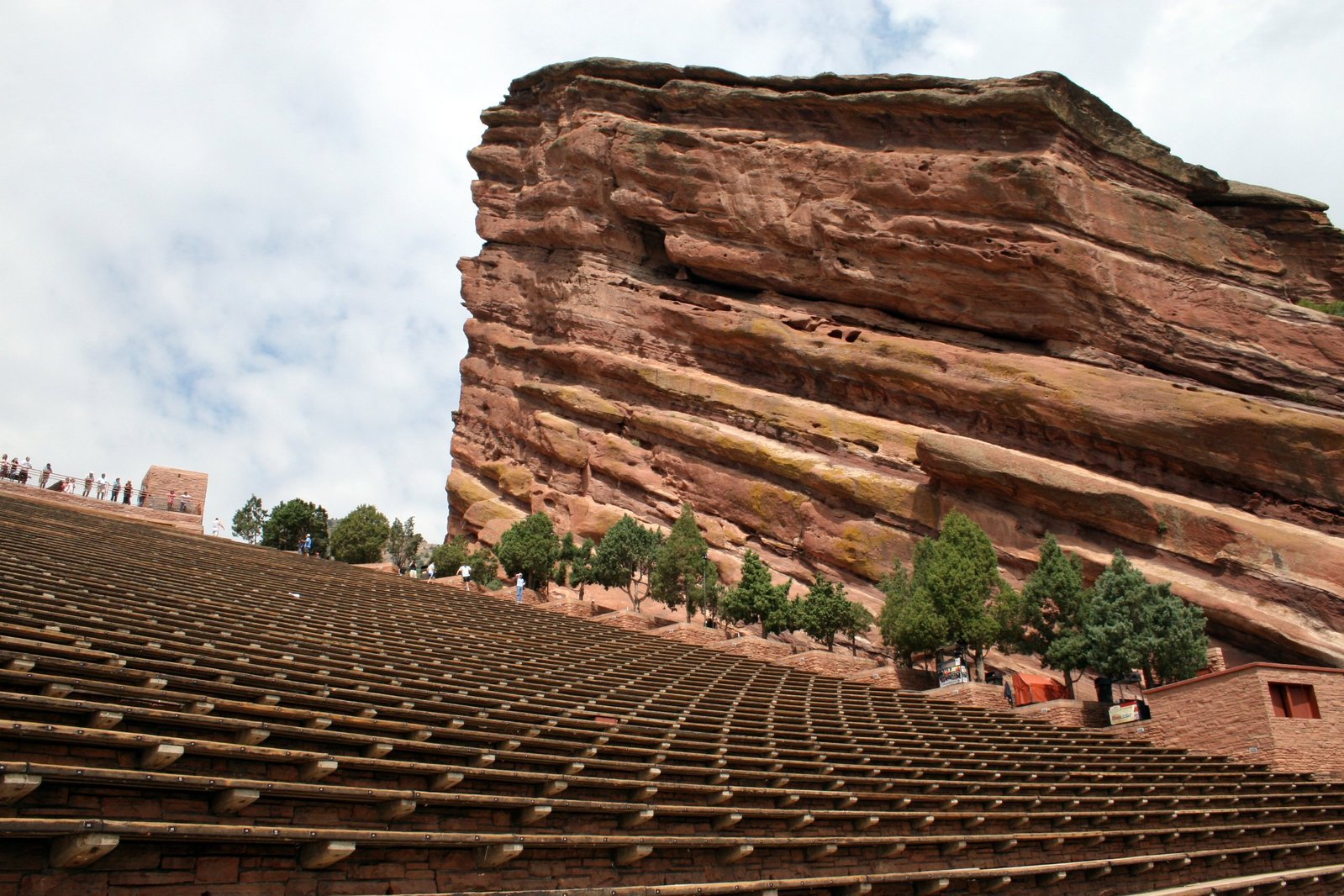 a stage with many seats on it in front of a large rock