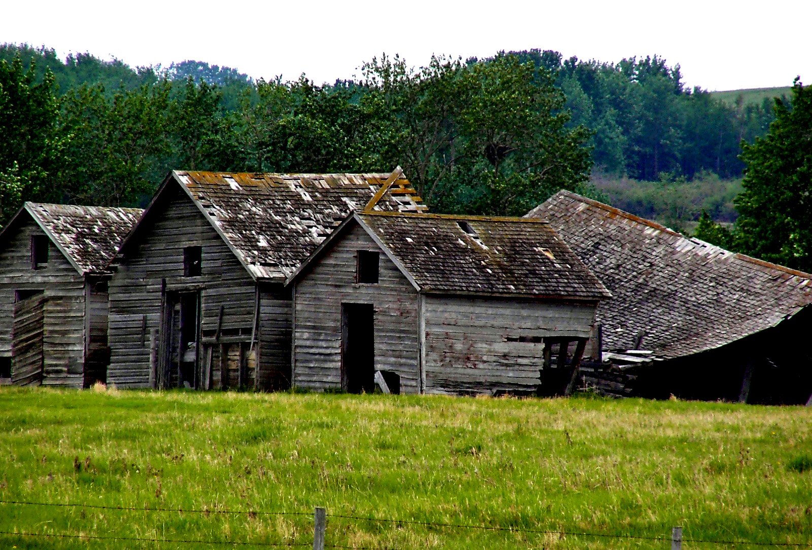 an old farmhouse with roof made out of wood and rust