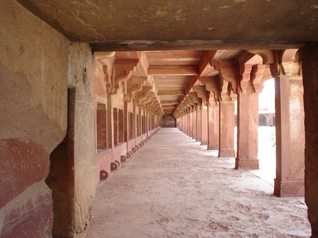 a long row of long columns sitting under a bridge