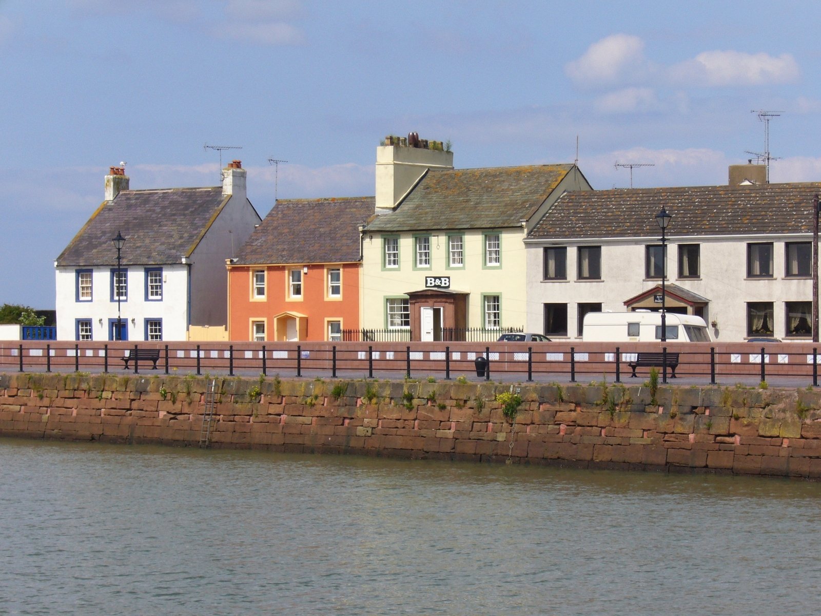 several town buildings with a lake in front