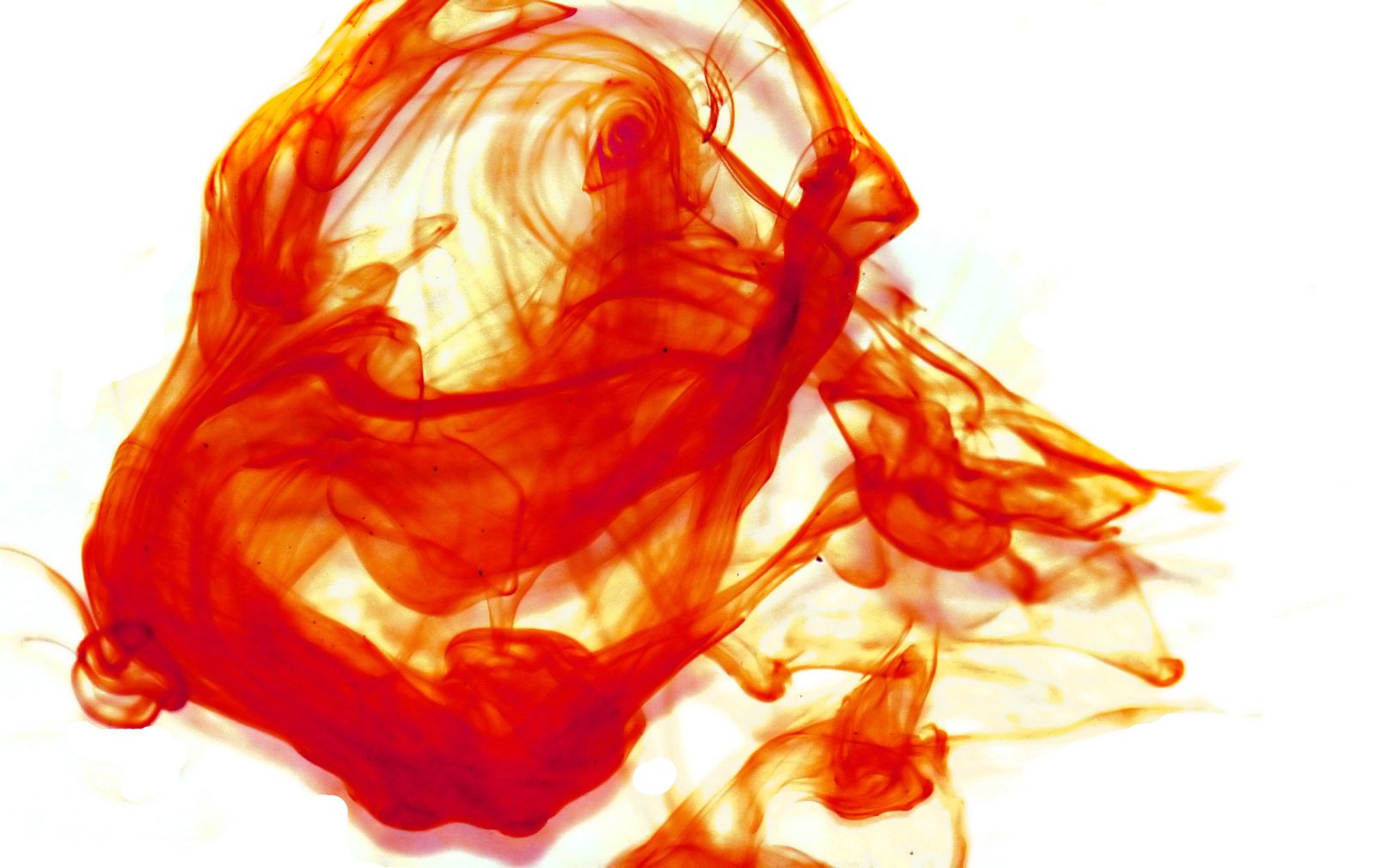 red and orange swirling liquid sitting on top of a white surface