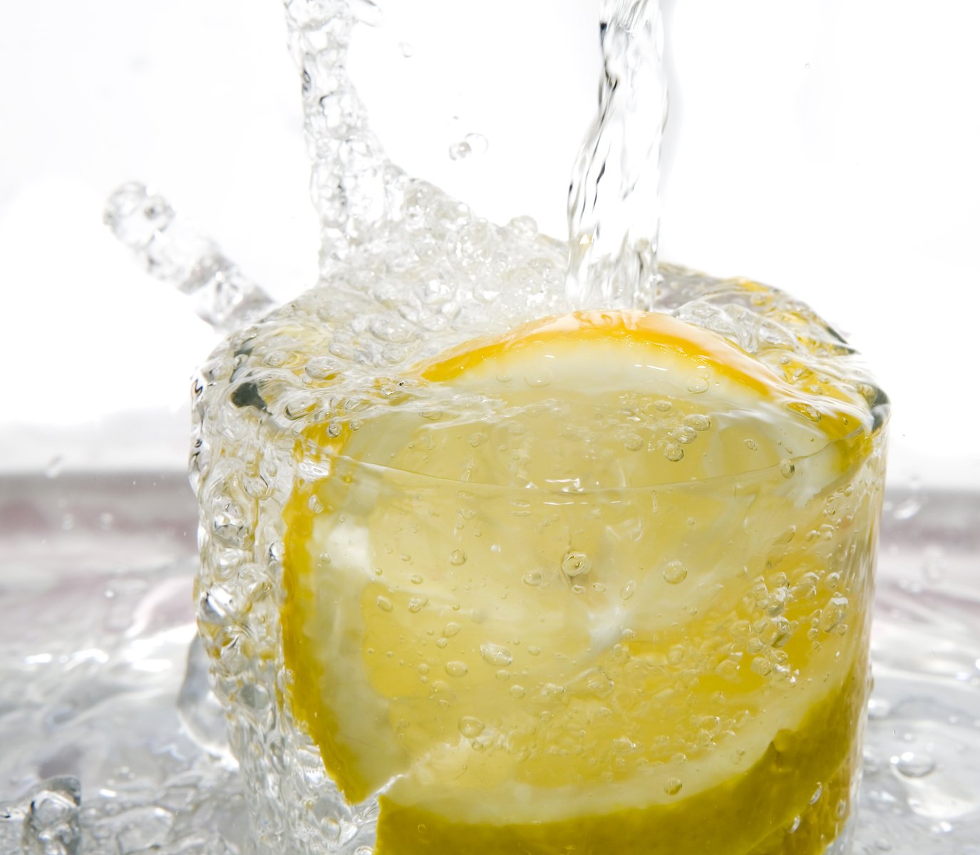 a large lemon under water with bubbles and light