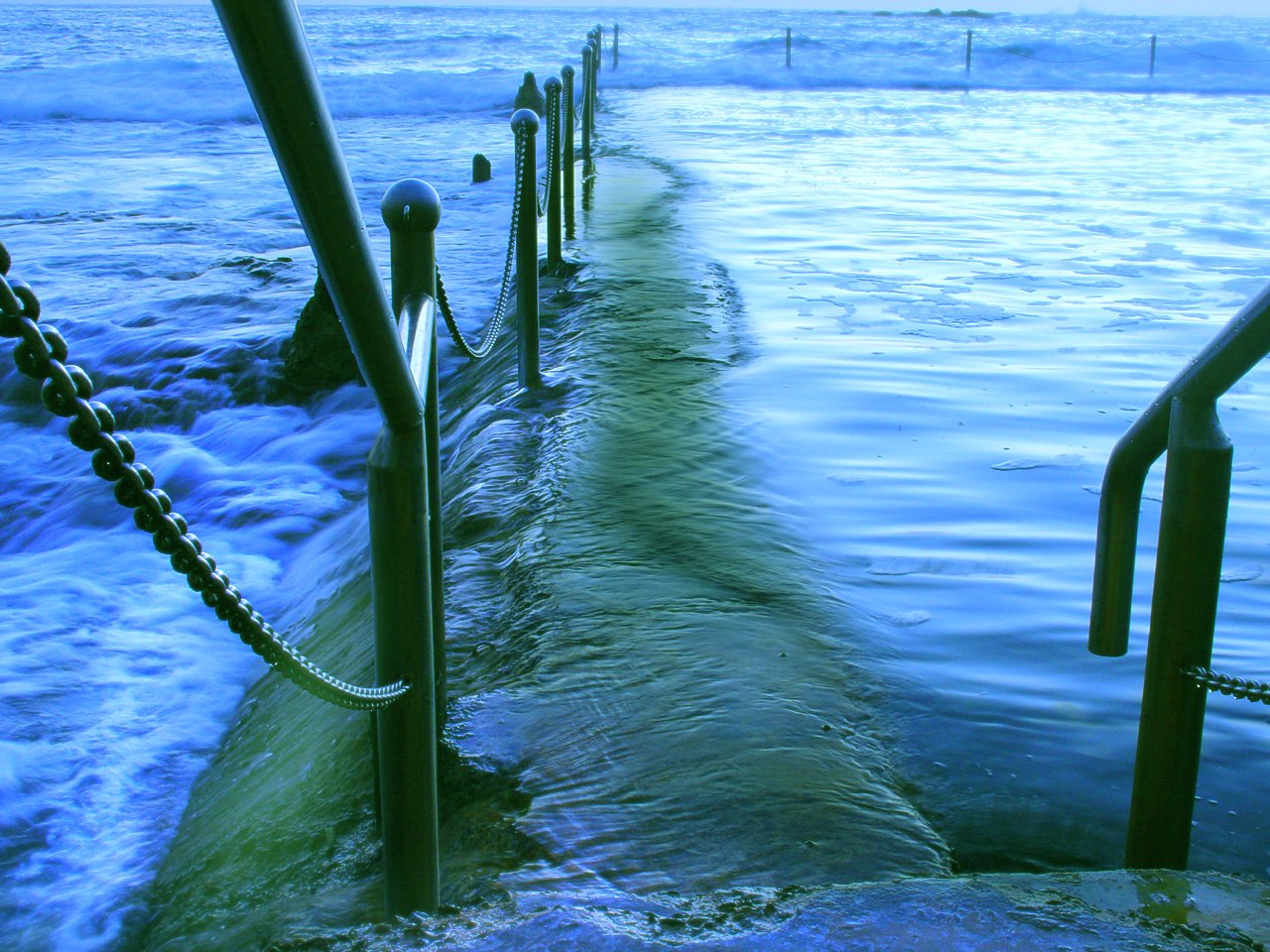 the ocean waters flow in to the water with hand rails and rope