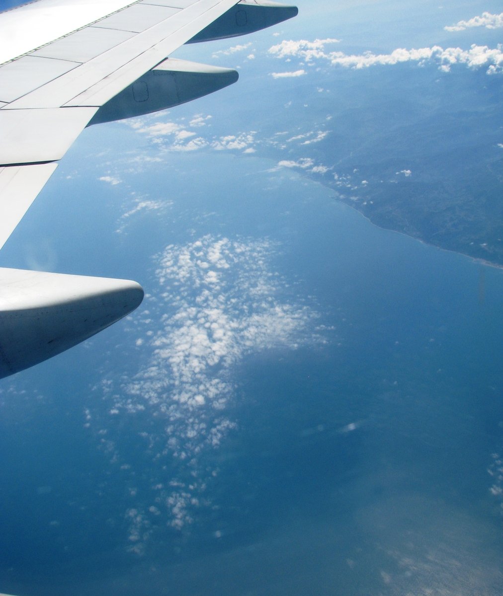 a jet is flying over the water that has been under the clouds