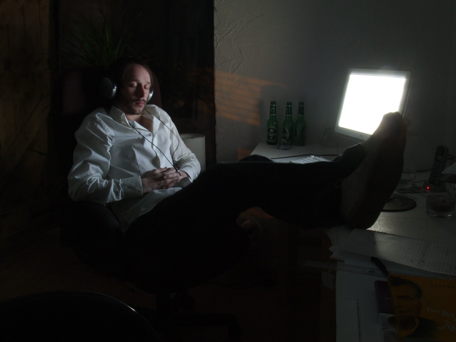 a man in a white shirt is sitting by a desk