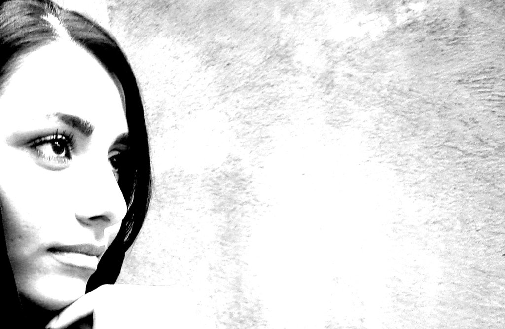 a woman's face with the background being covered by a black and white po