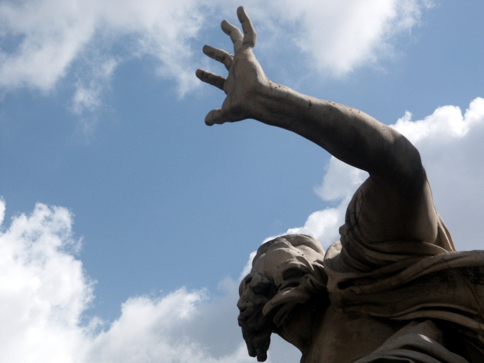 a statue of a hand reaching to grab soing