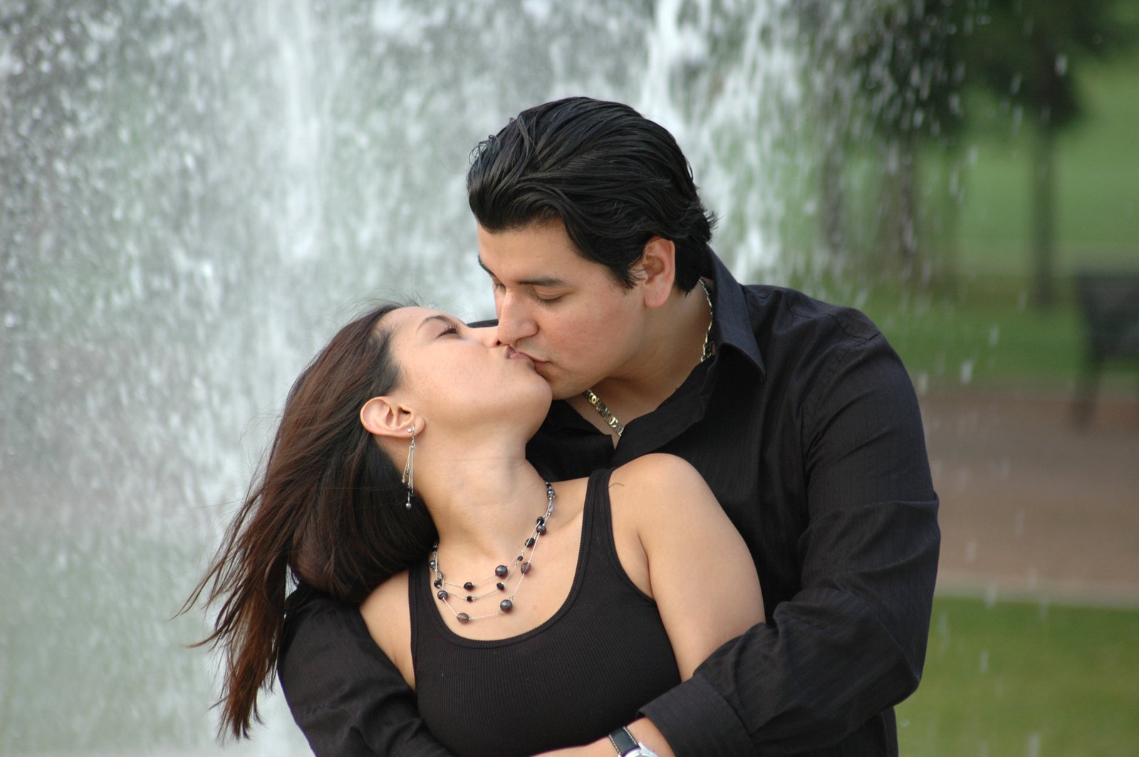 two people that are kissing by some water