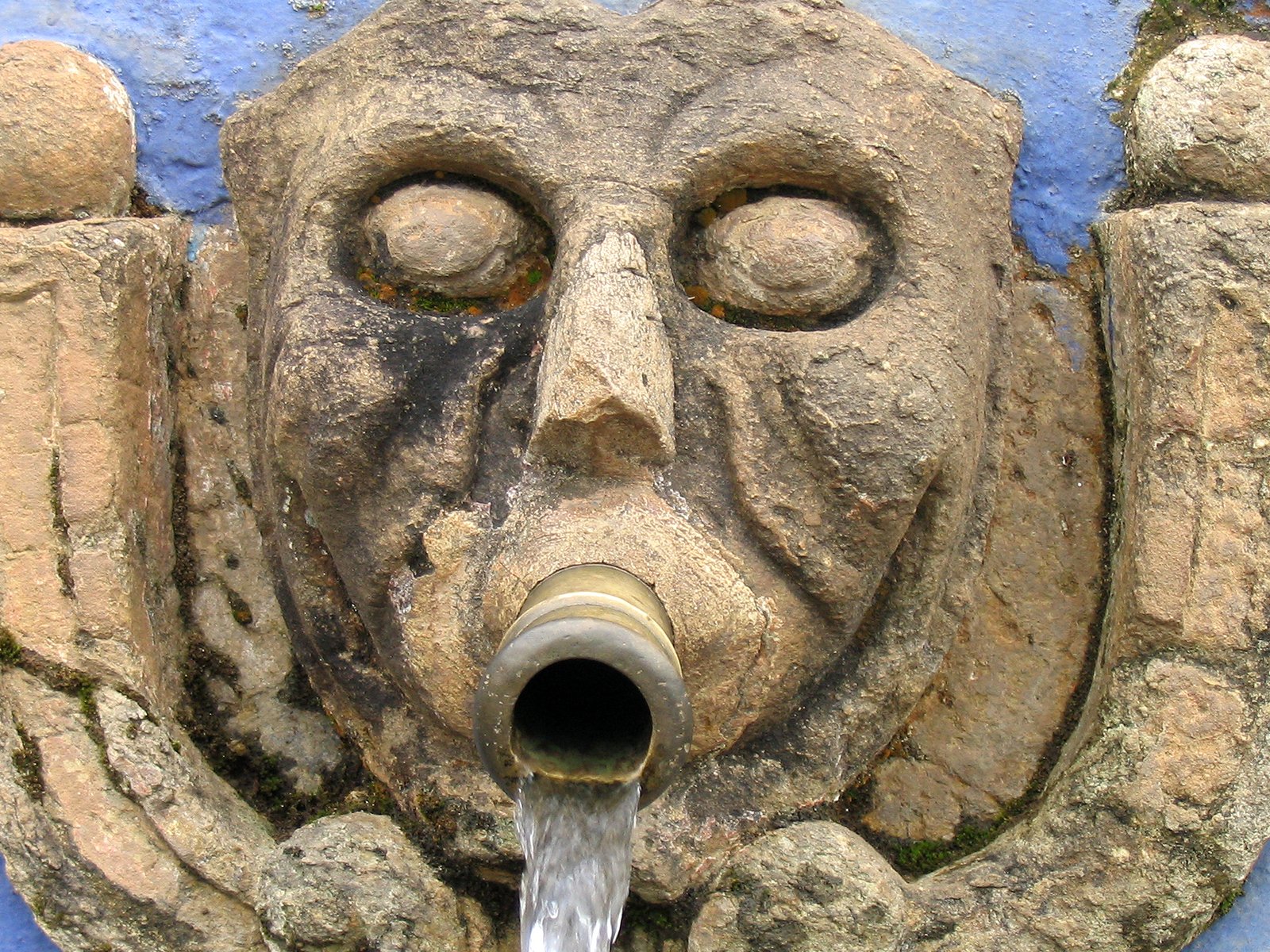 a mask made out of rock that has a pipe in it