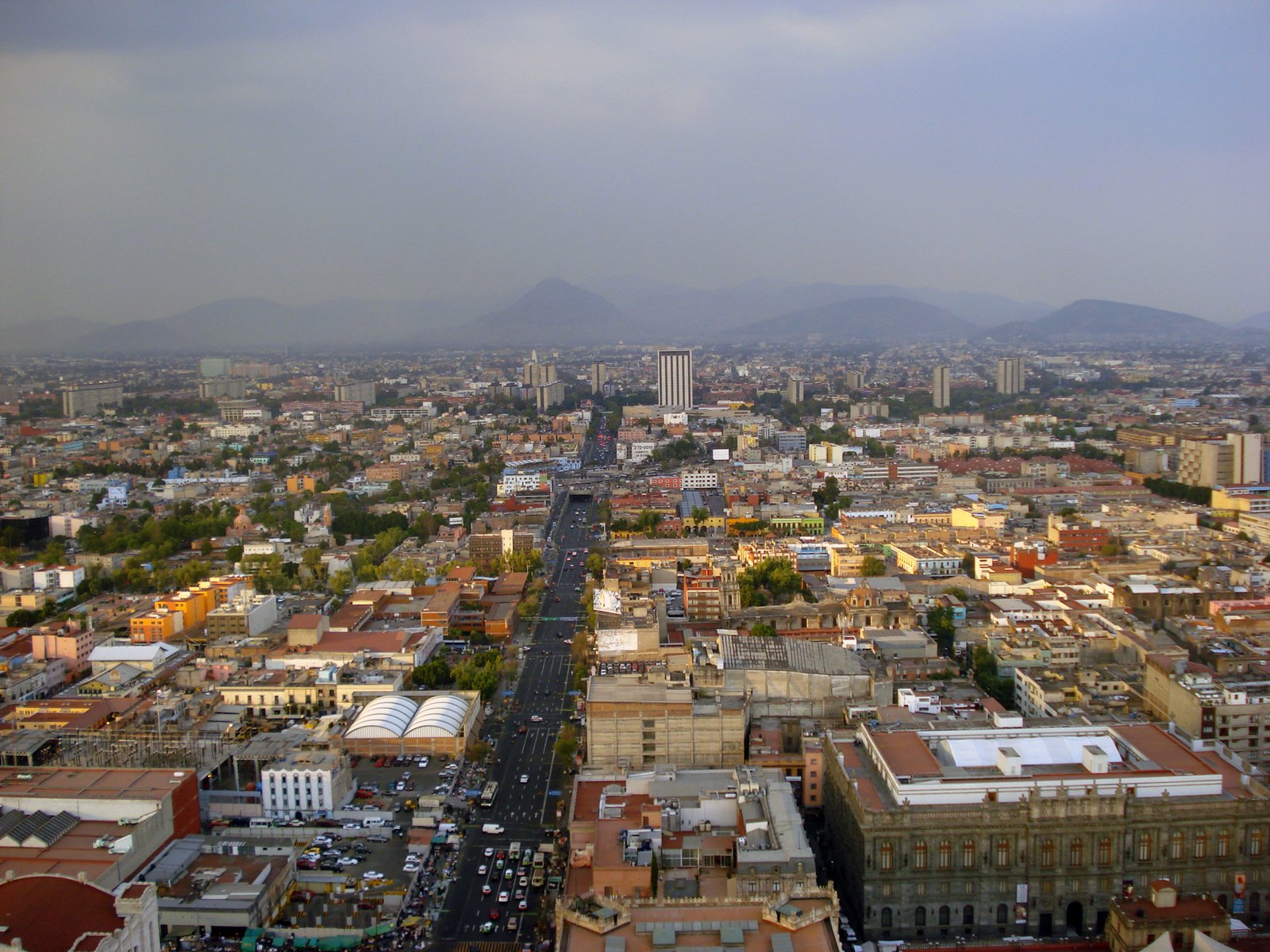 an aerial view of a city with cars going around