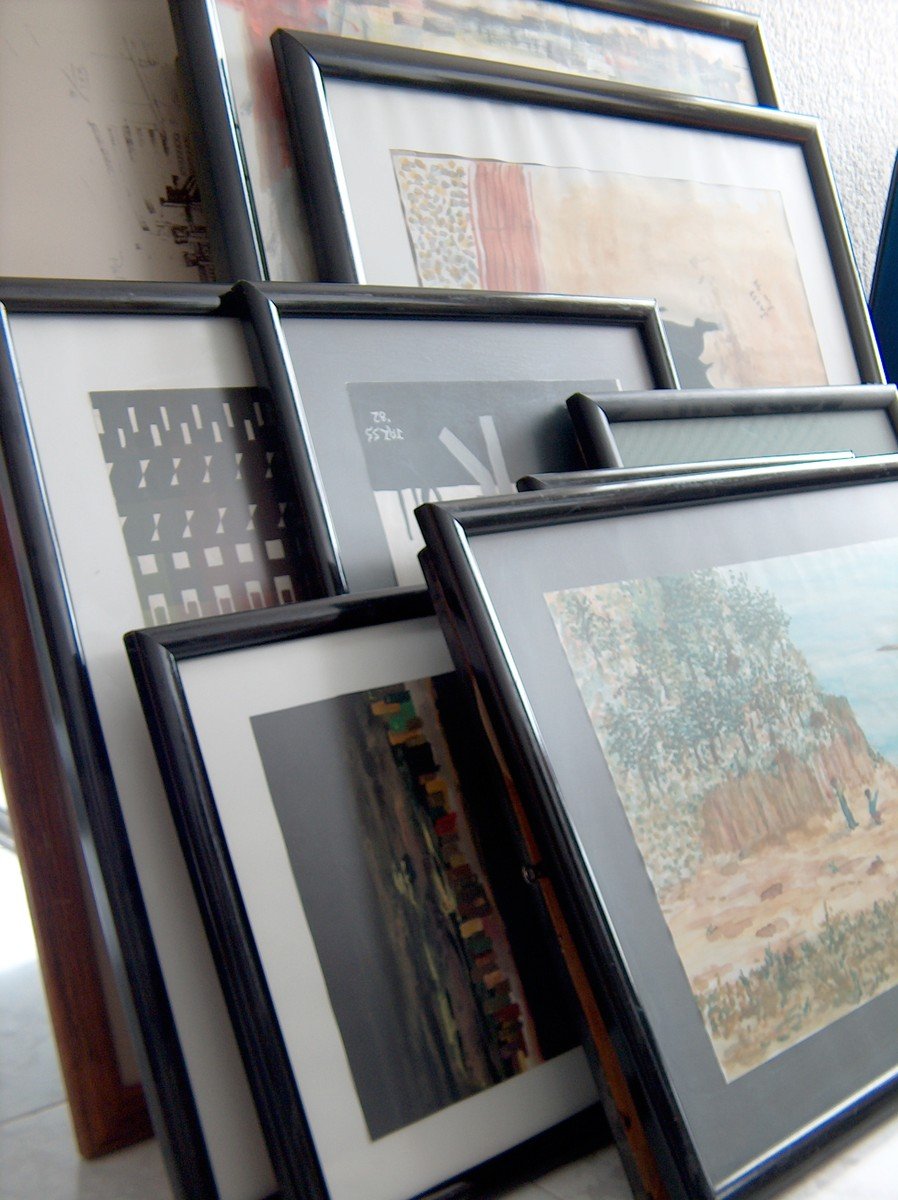 multiple framed artwork are displayed near a wall