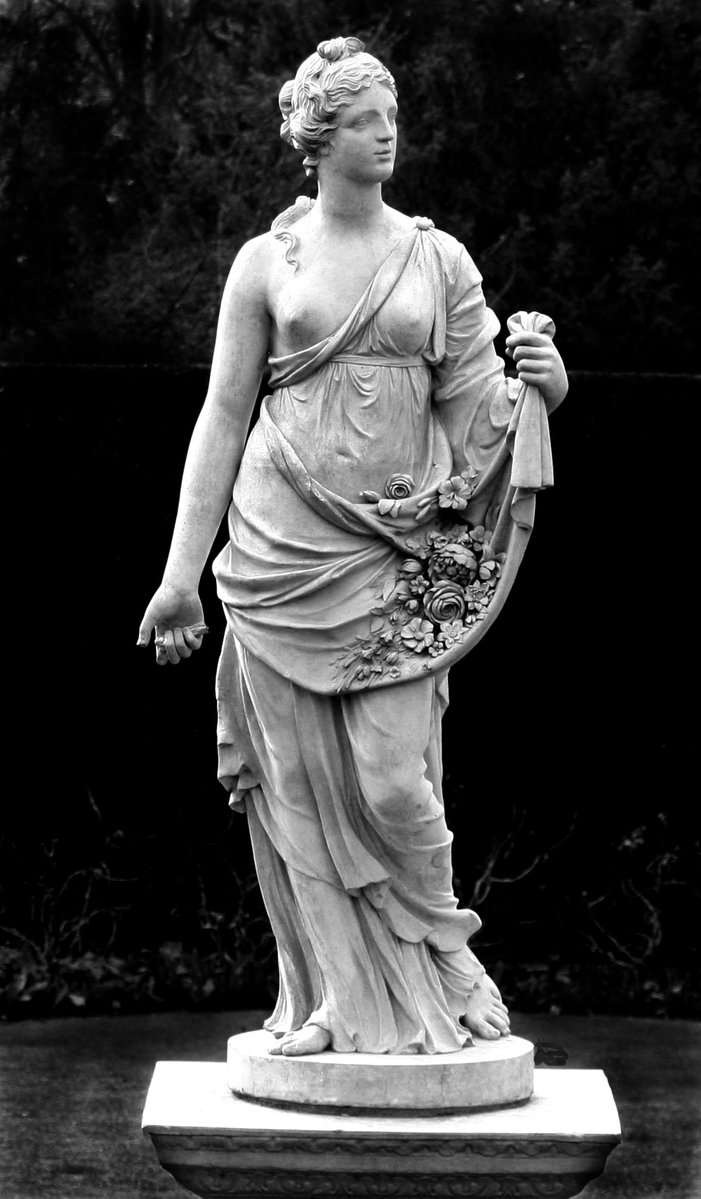 the statue of a lady holding a bouquet of flowers