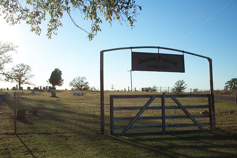 a fenced off sign sitting over an empty farm field