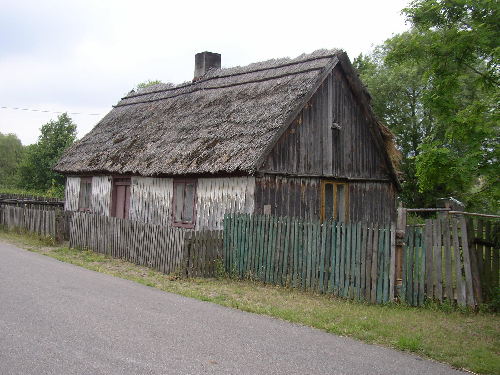 a very old wooden house with a big thatch