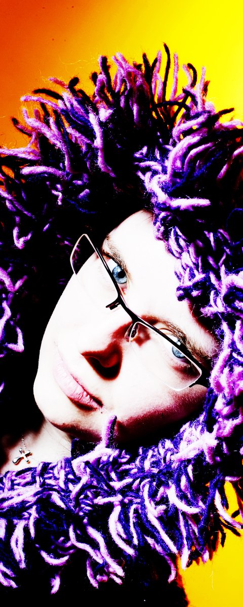 a man with glasses and a purple hair is wearing glasses