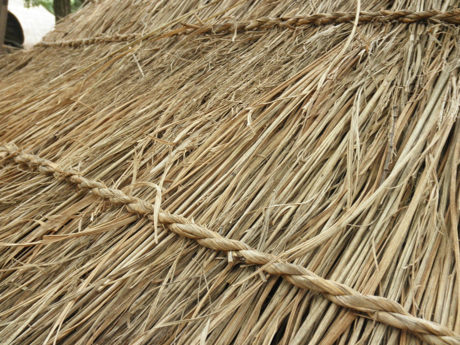 a grass hut that is covered in straw