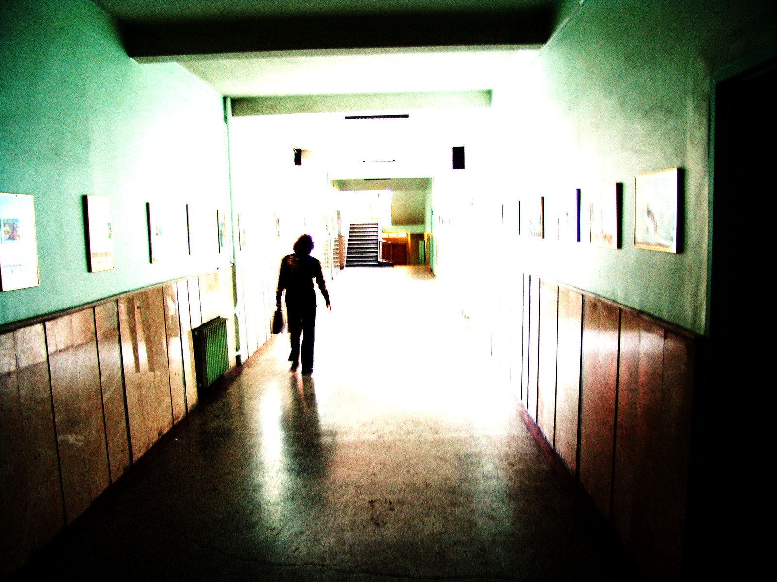 person in silhouette walking in an apartment hallway