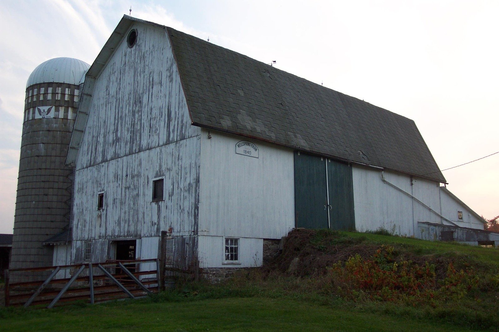 a old barn sitting next to a green field