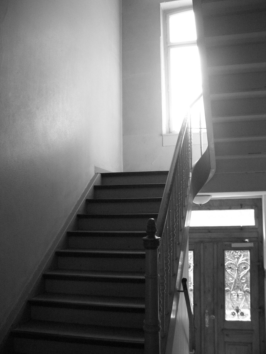 black and white po of stairs in front of window