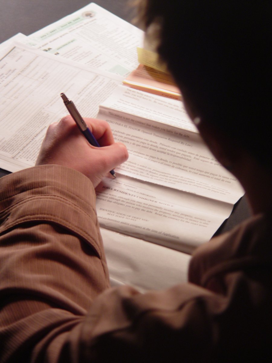 a young man working at his desk writing in an open planner