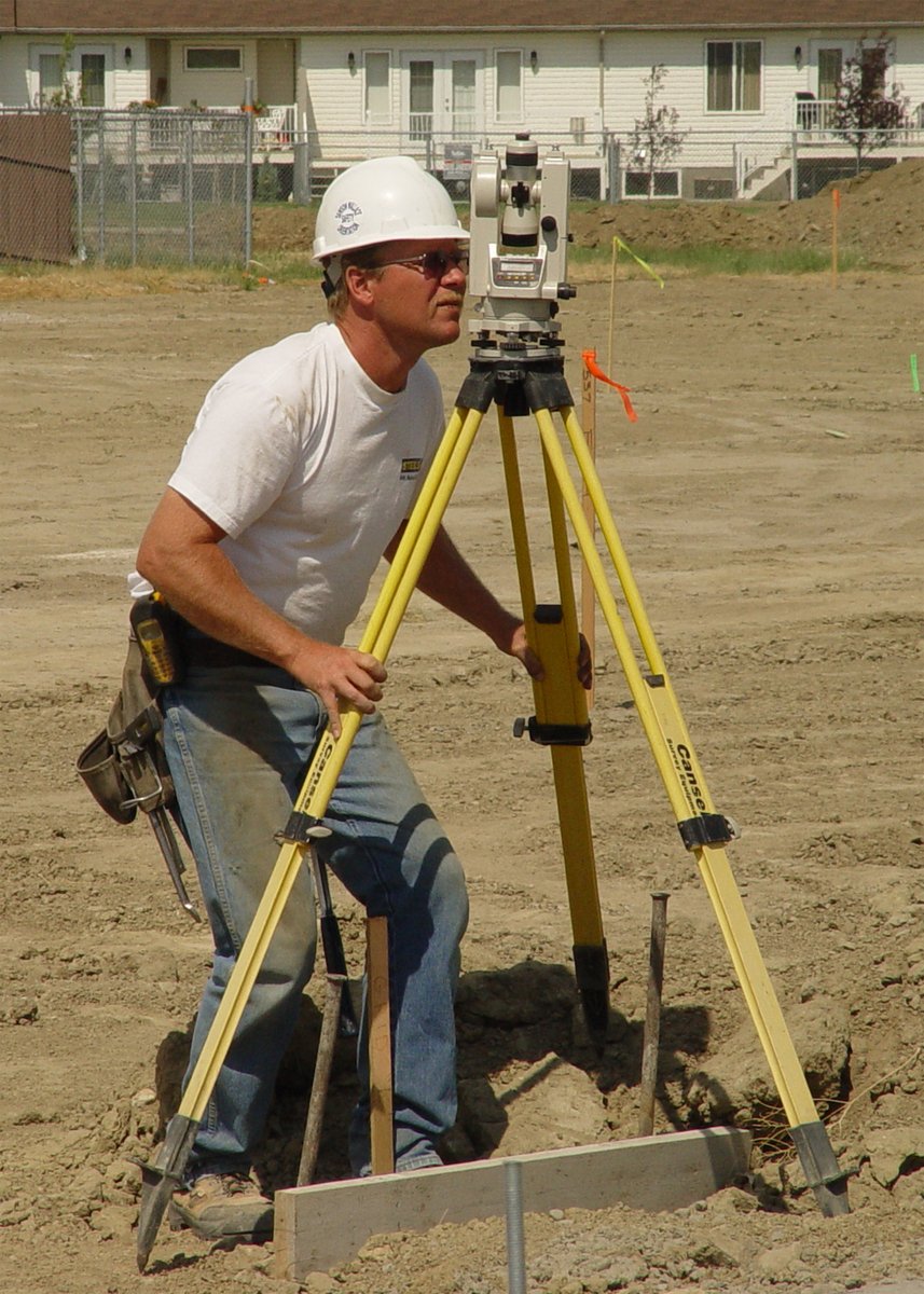 a man using a tripod on top of a building