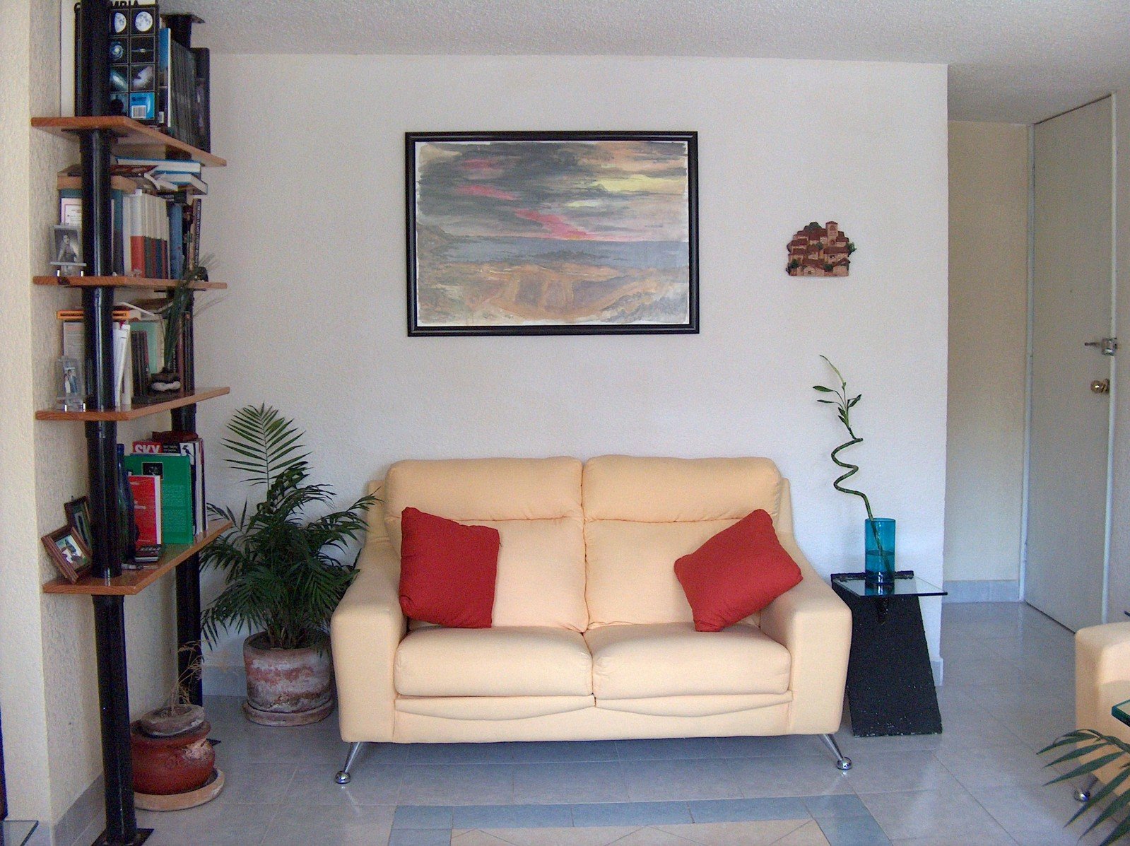 a beige colored couch with pillows is in the corner of a living room