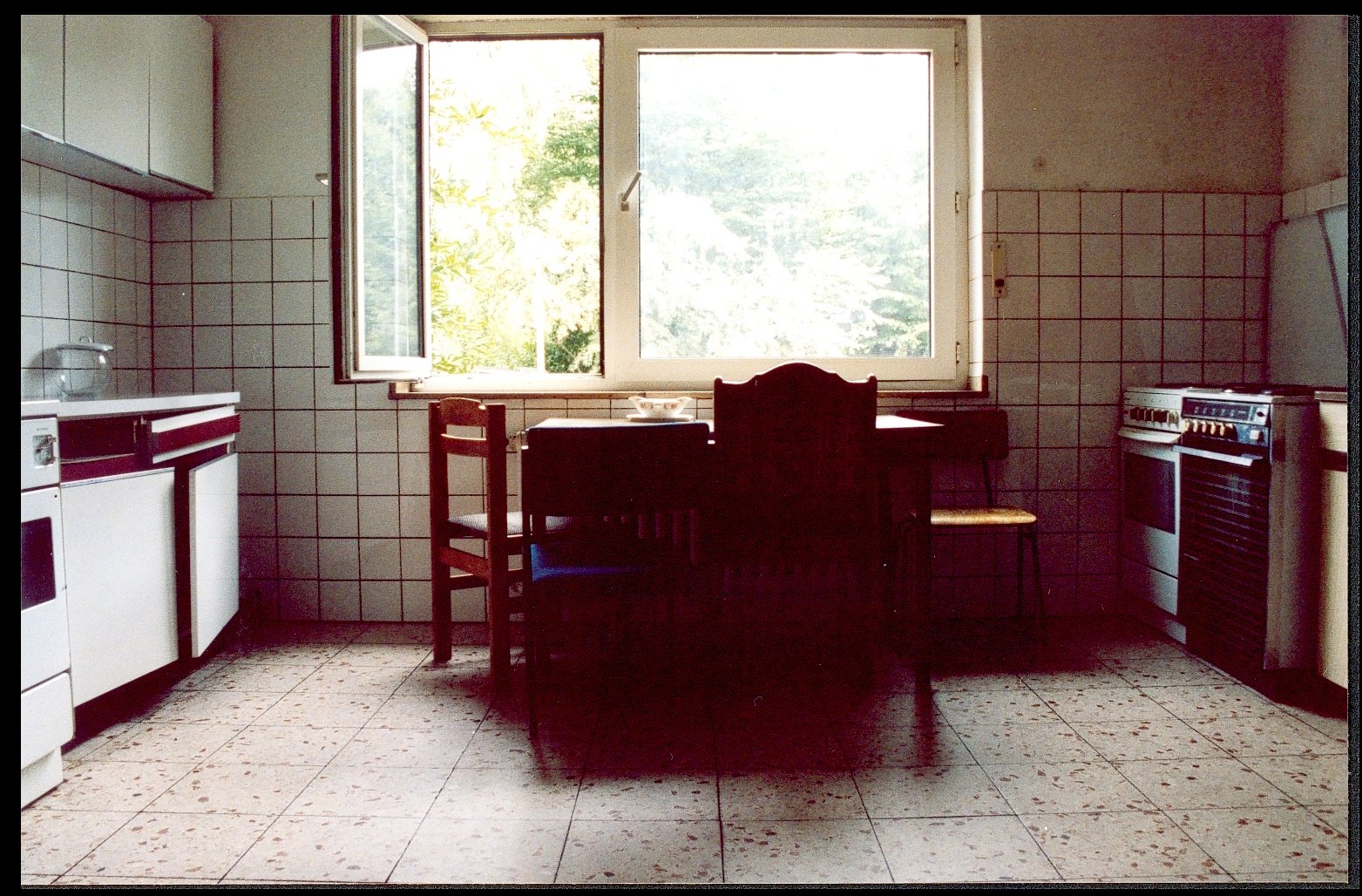 a table and chairs with the open window