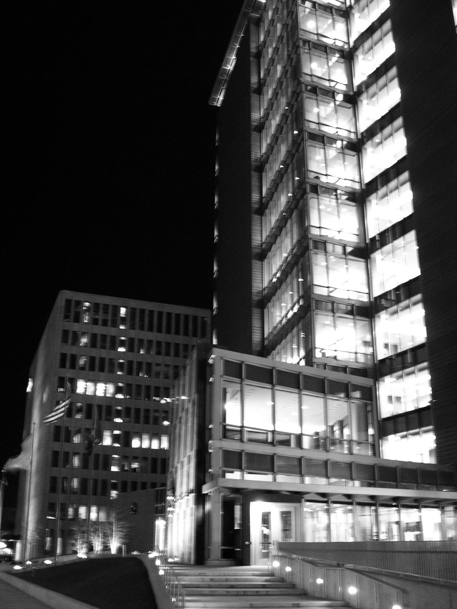 black and white image of a building with several lit up windows