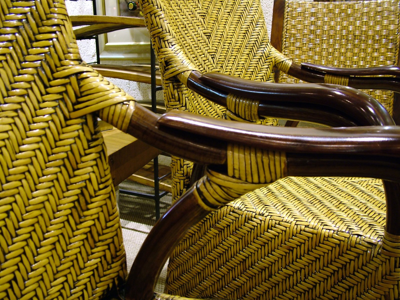 two brown wicker chairs, each with different arm styles