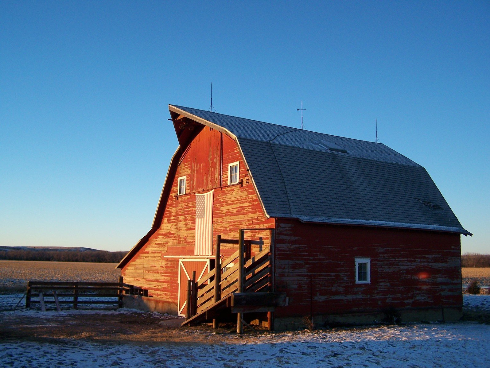 a red barn with windows in the snow