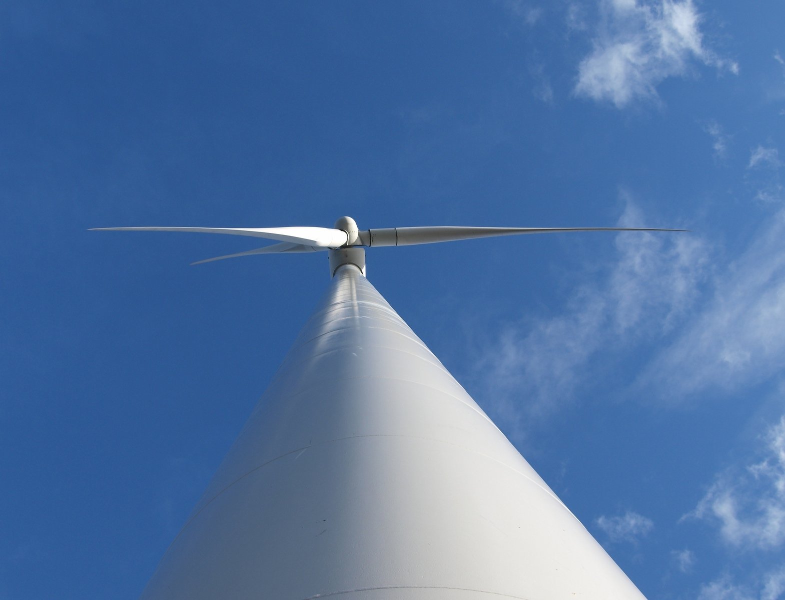 the white wind turbine has a long, curved top