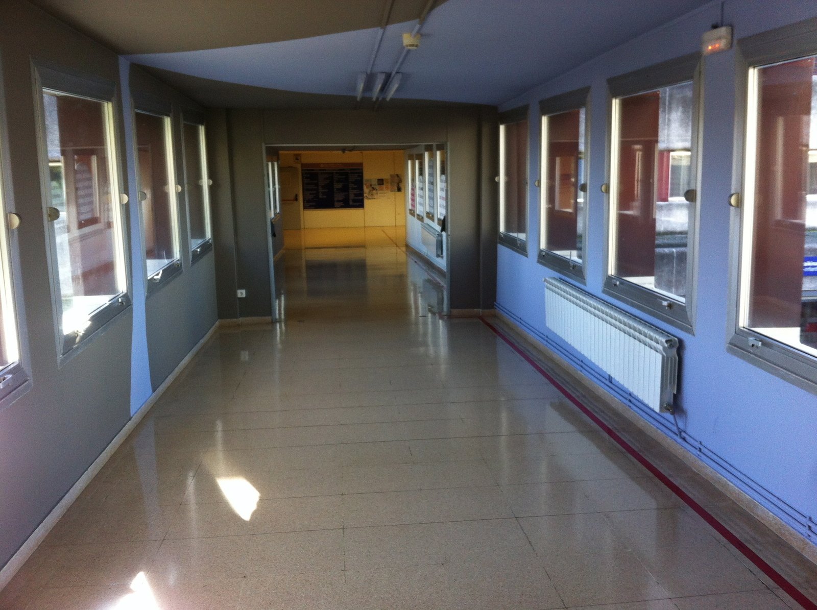 the sun shines through windows on an empty hallway