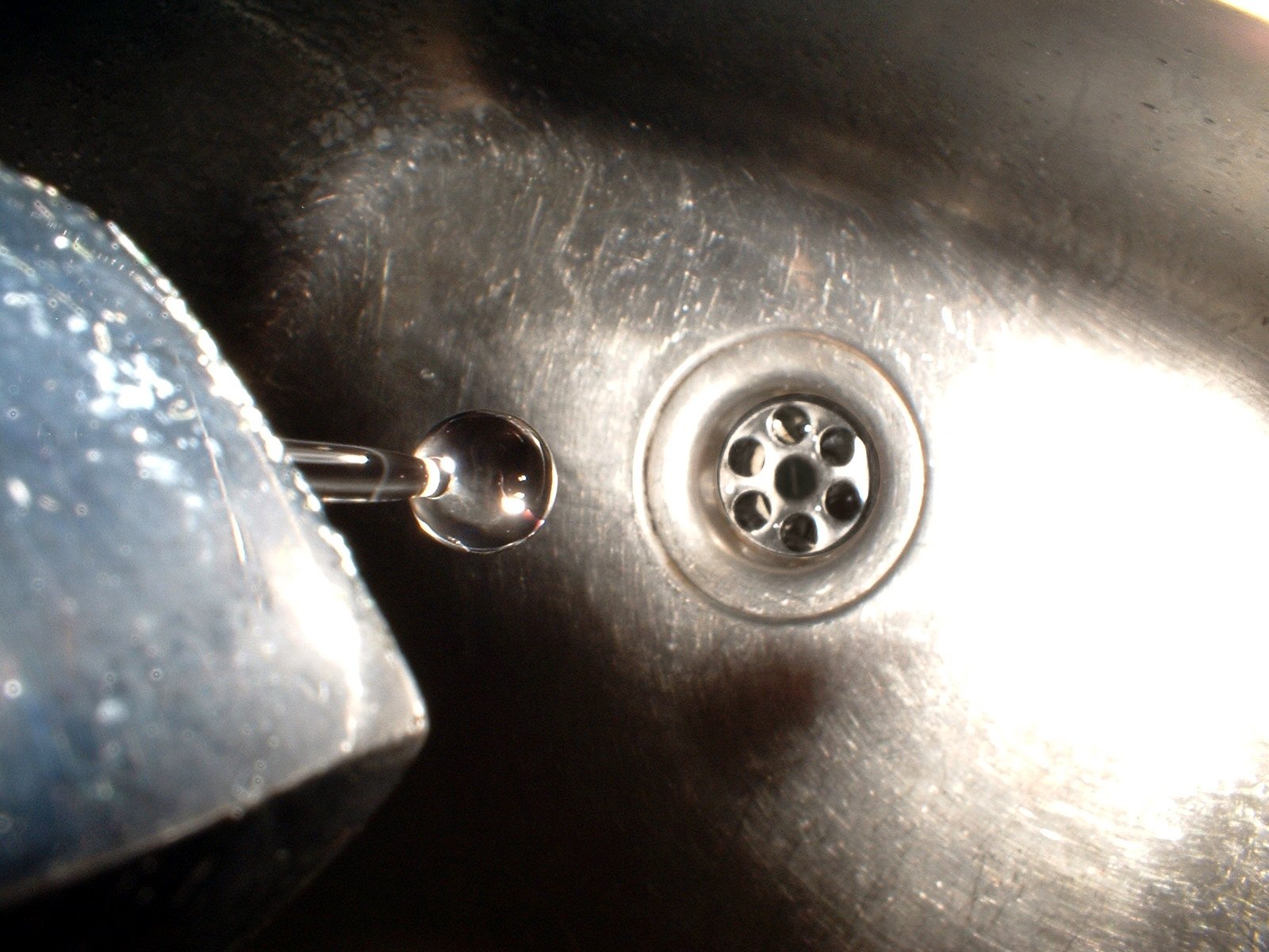 a closeup s of the faucet in this stainless steel sink