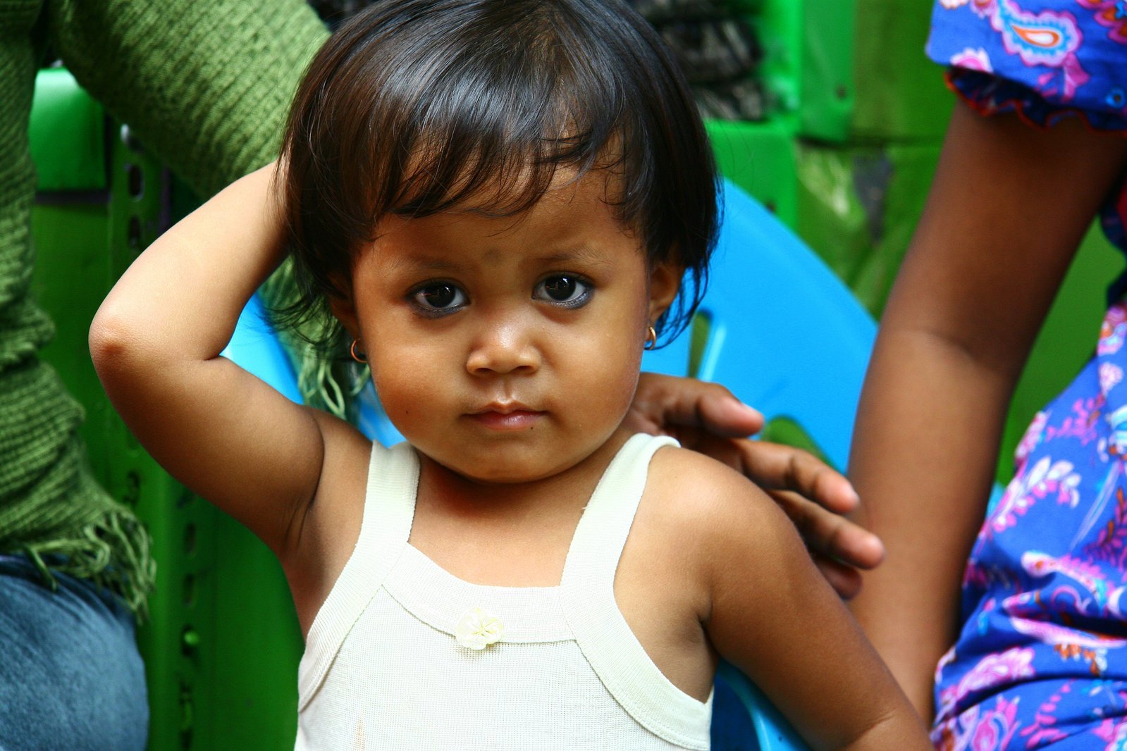 a close up of a toddler with one hand on her head