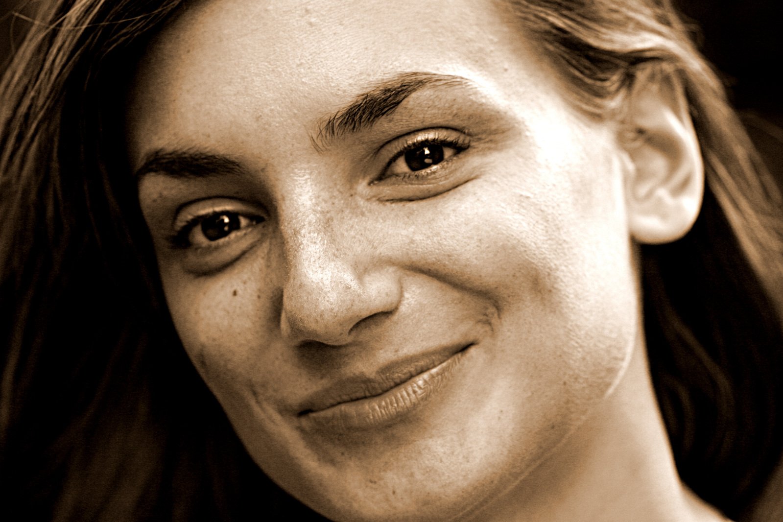 a close up s of a woman with long hair smiling