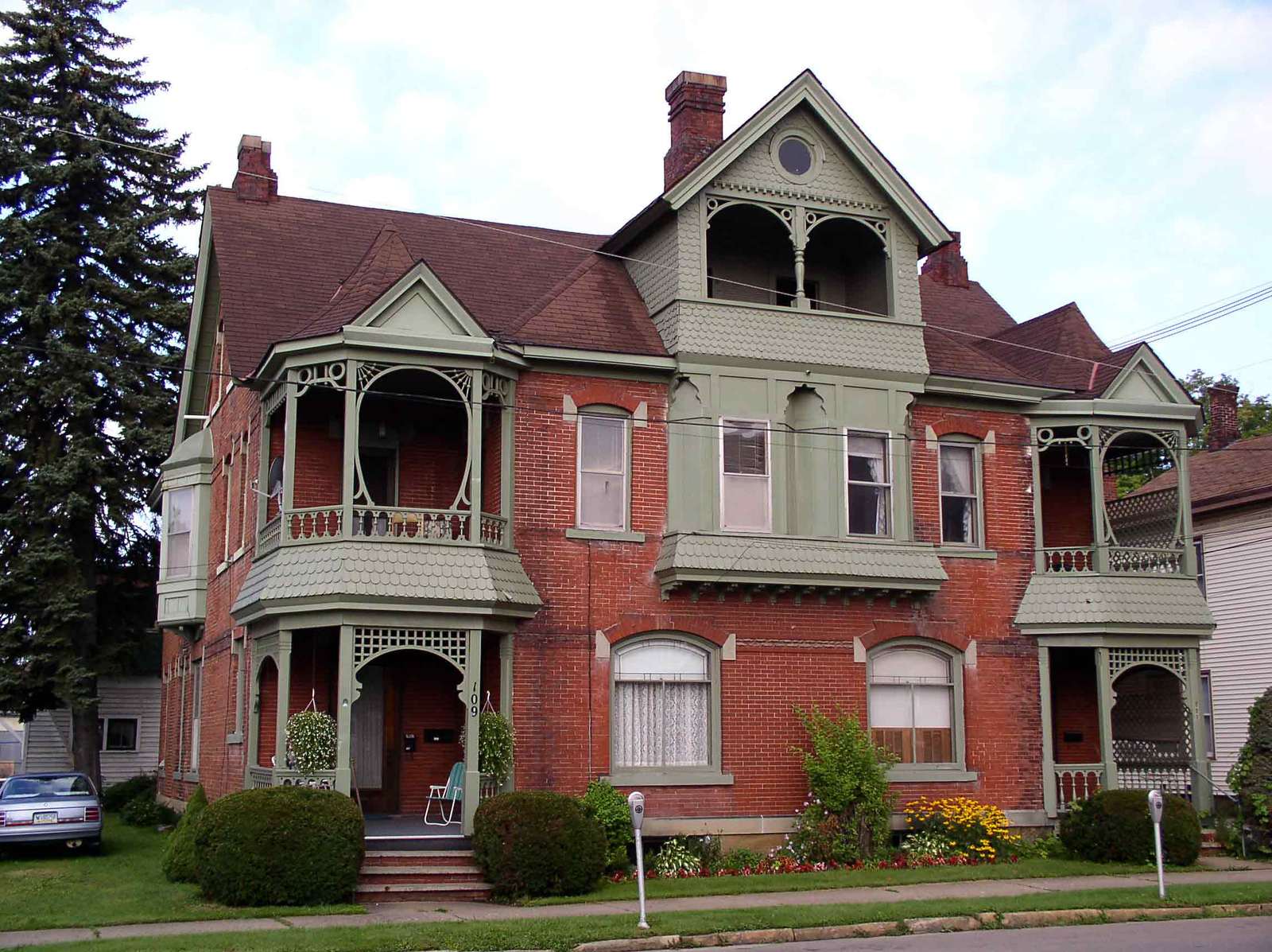 a big red brick house with porches and windows