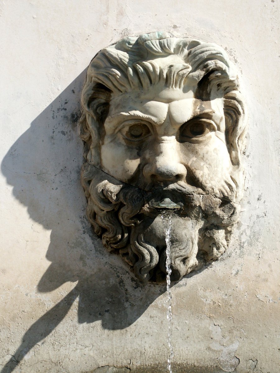 a water fountain that is mounted on the side of a building