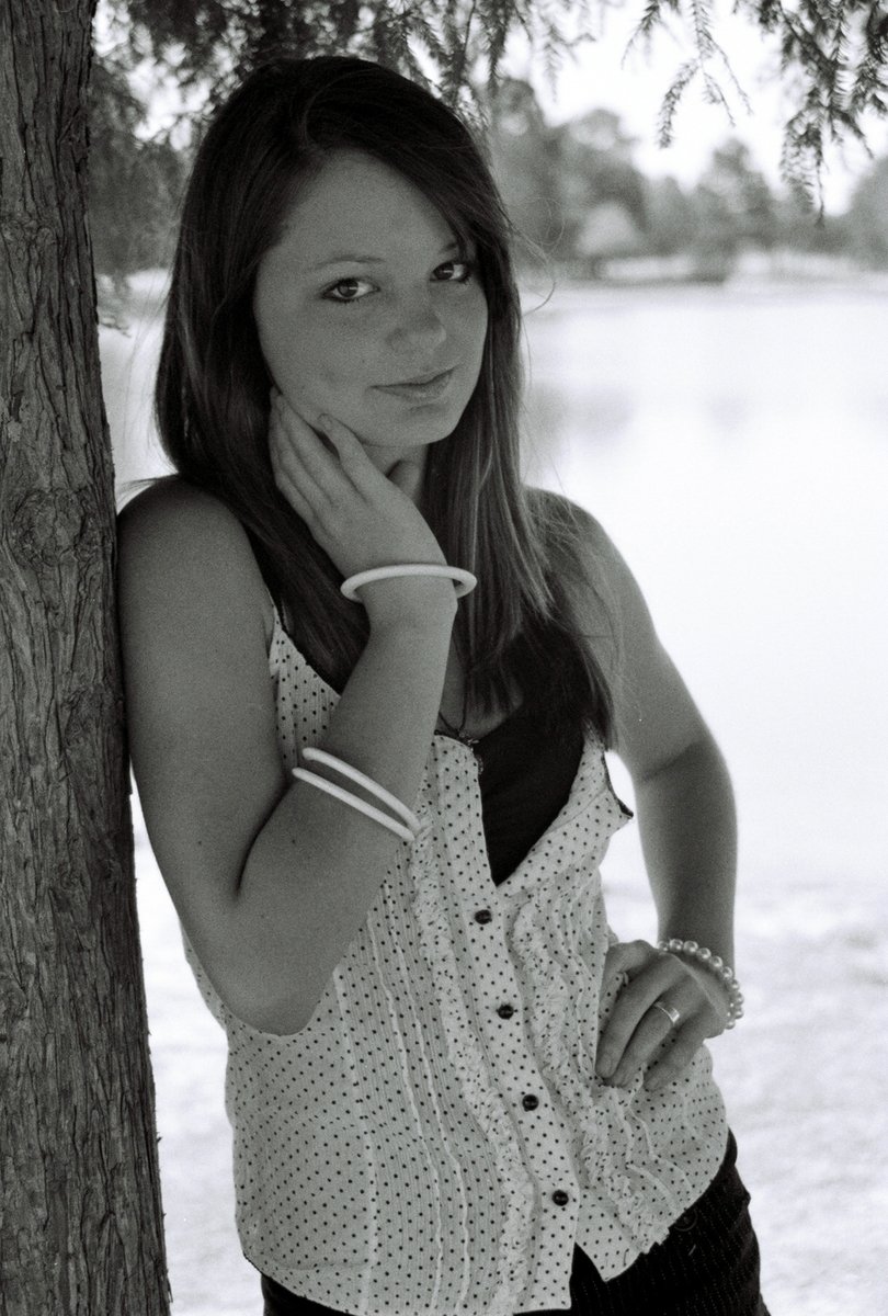 the girl poses near the water for the camera