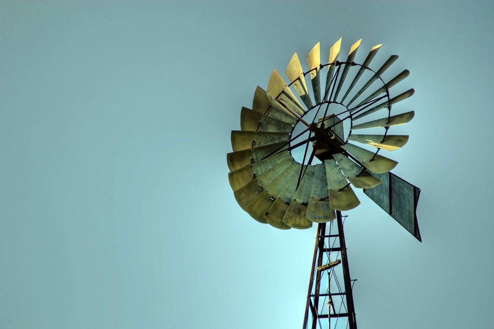 the windmill is leaning on its side against a blue sky