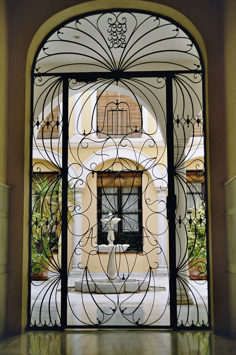 an art nouveau iron and glass door with a view