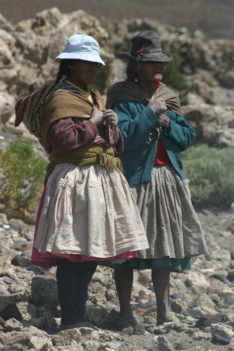 two women in traditional dress on rocky terrain