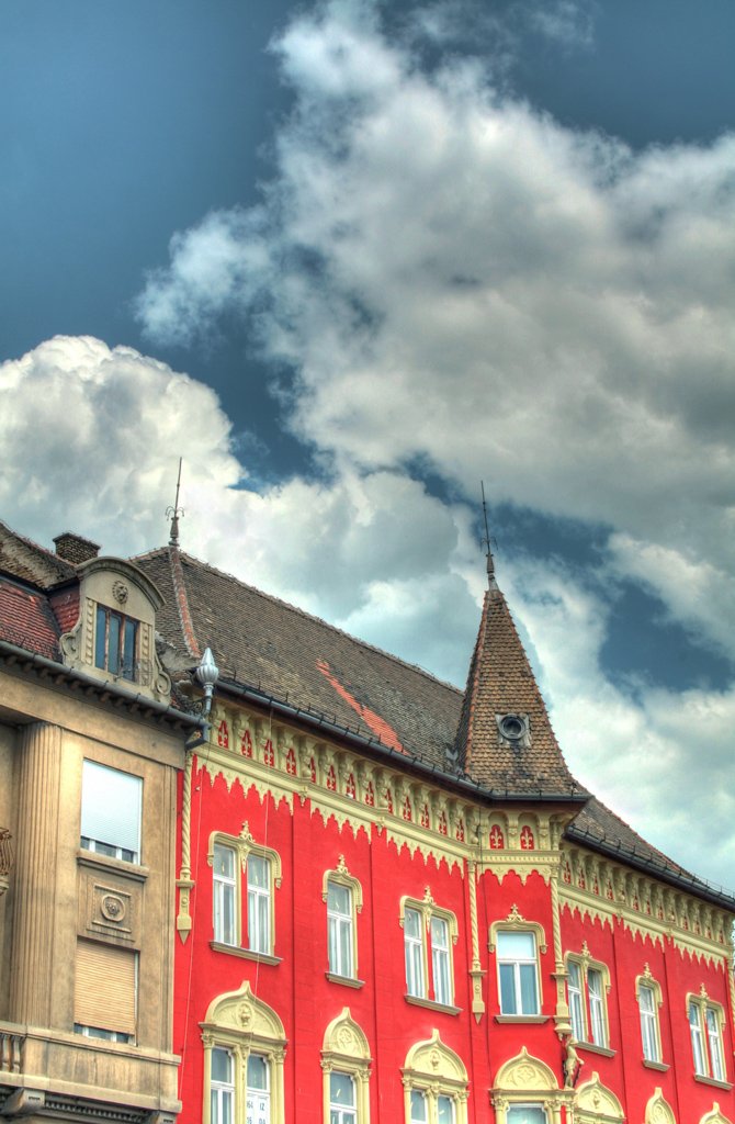 a red building with many windows and a sky in the background