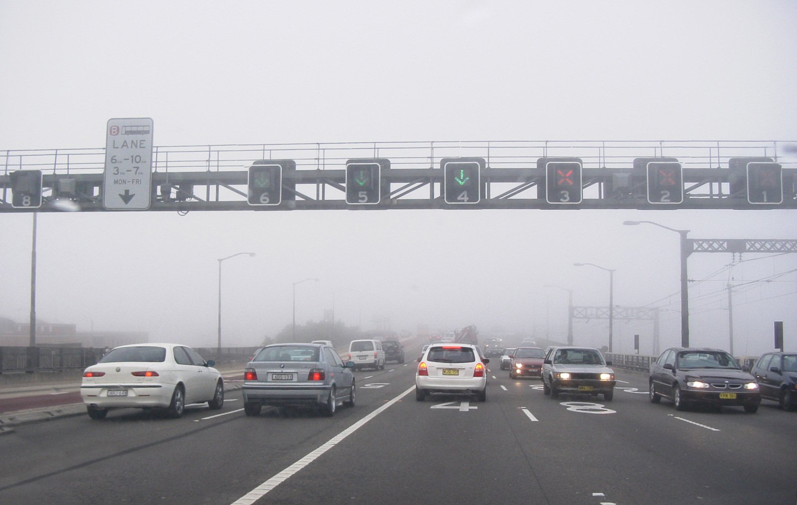 cars are driving on a highway in the fog