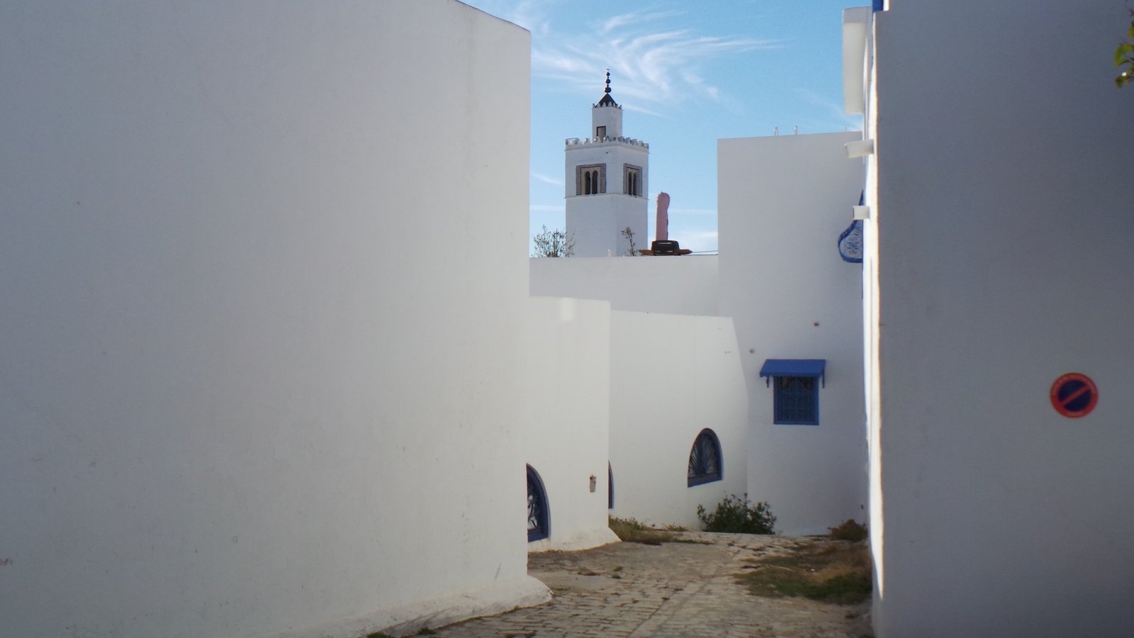 a small street that has a white building in the background
