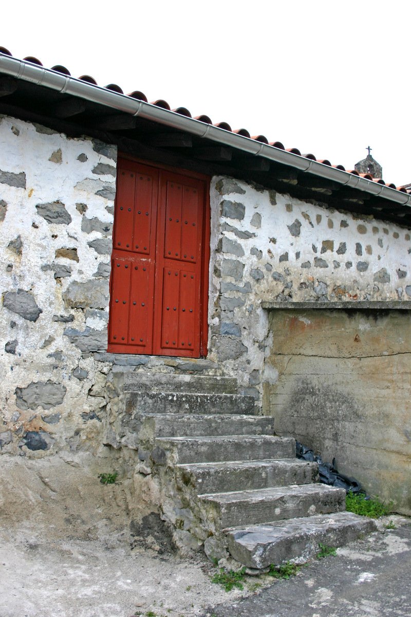a rustic house with steps leading up to the outside
